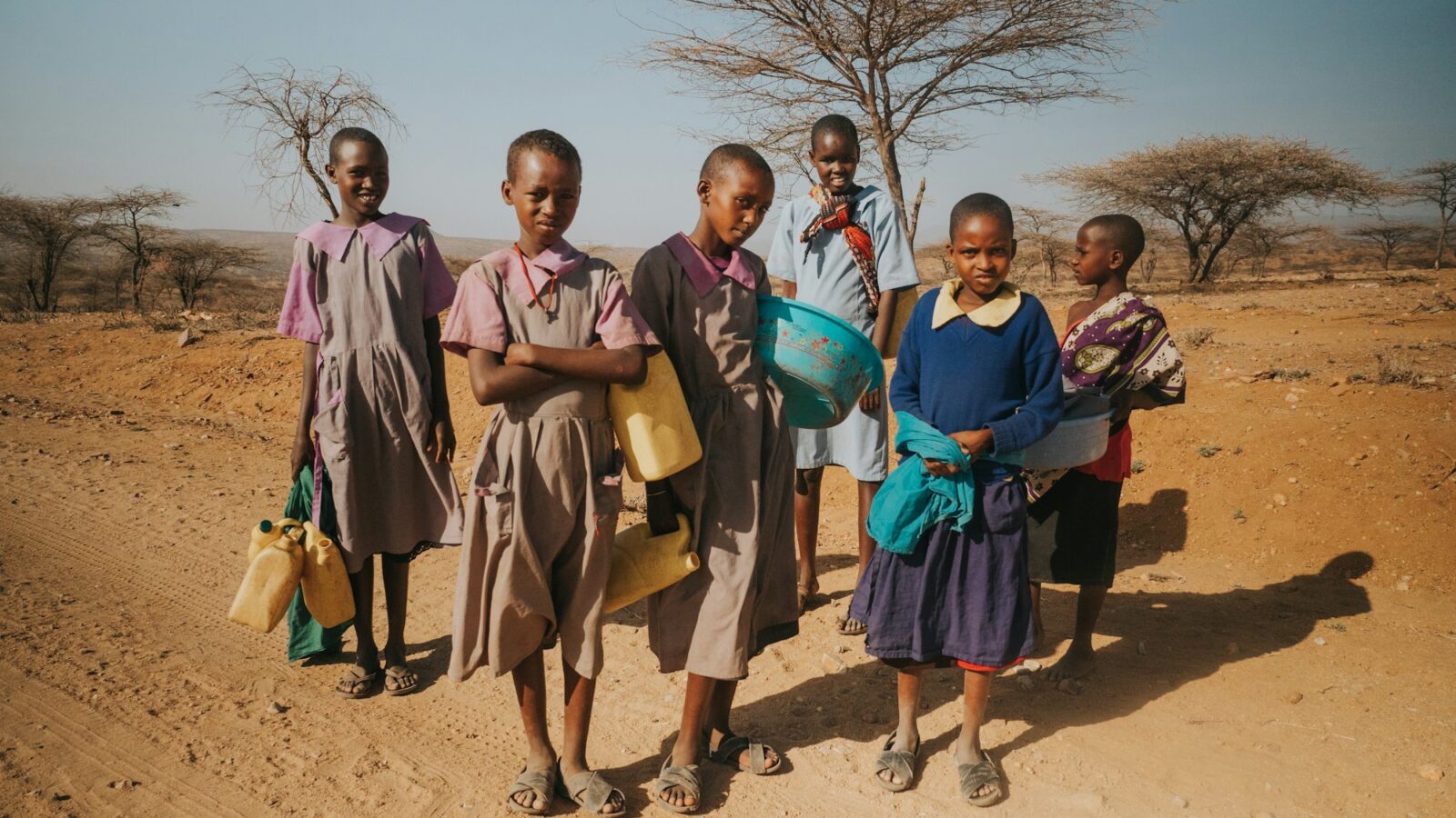 Children standing in a dry landscape