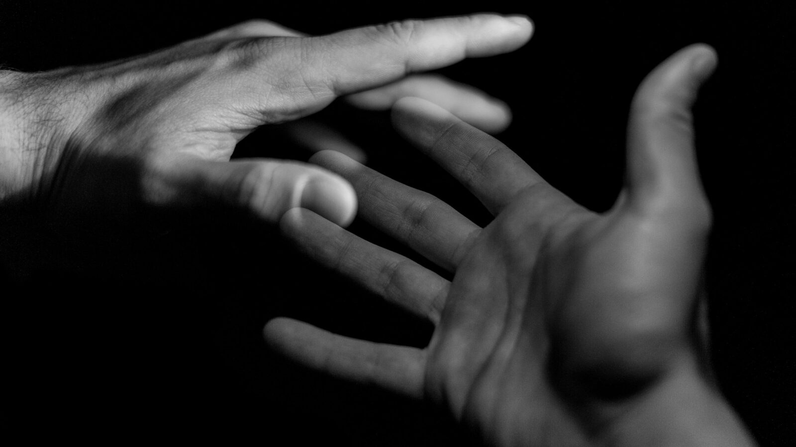 Two hands reaching toward each other