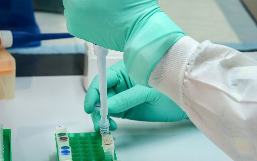 A researcher using a pipette in a microbiology lab