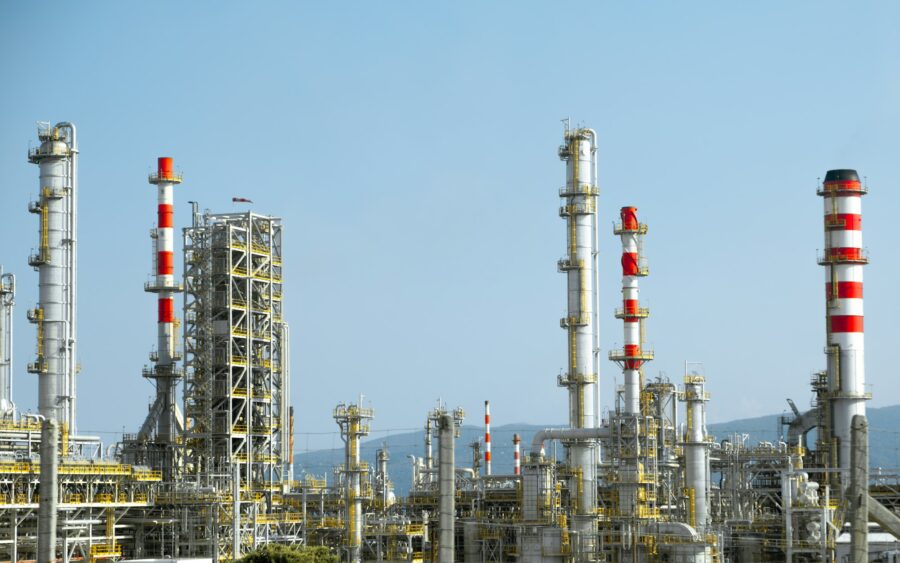 An industrial plant with tall red and white stacks