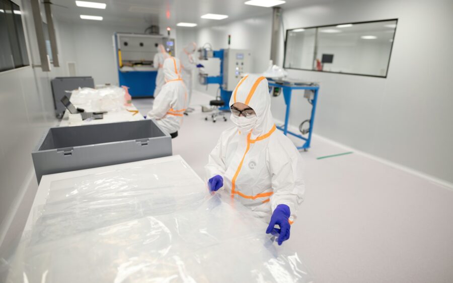 Workers in protective suits inside a cleanroom