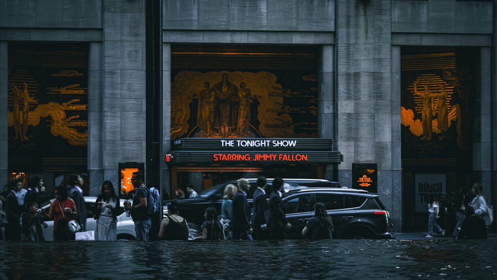 People and cars in a flooded city street
