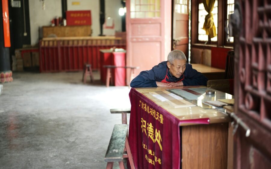An elderly man at the counter of a family shop