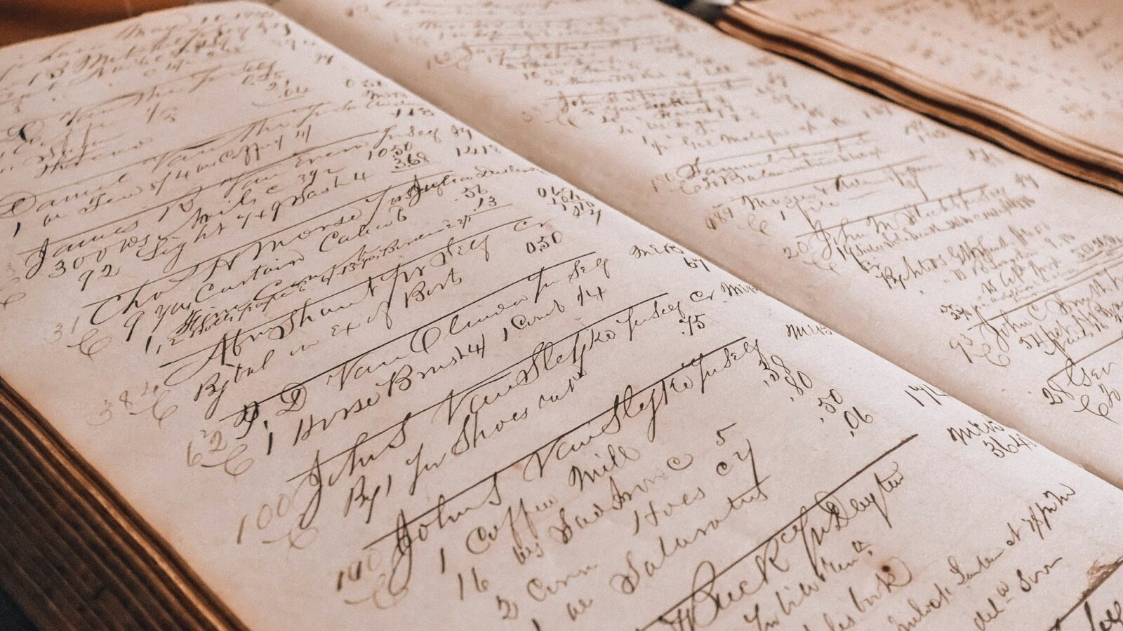 An old ledger with handwritten entries beside an inkwell